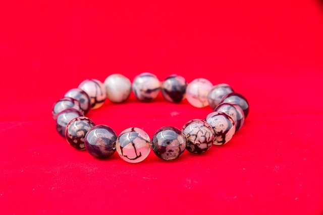 Rwanda Nyungwe micro-lot organic coffee in a premium kraft bag with a red wax seal detail on a rustic wooden surface surrounded by coffee cherries